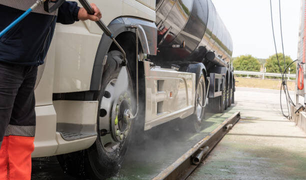 Truck driver cleaning the exterior of the vehicle.