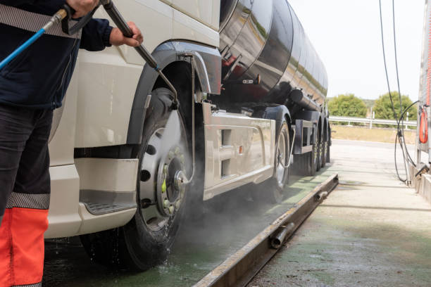 Truck driver cleaning the exterior of the vehicle.