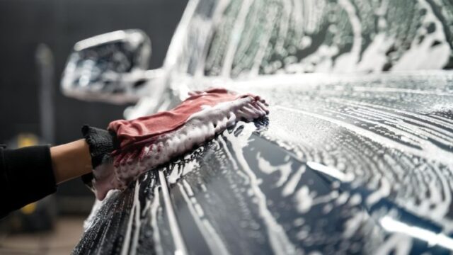 professional-car-wash-mano-de-trabajador-lavando-carroceria-automovil--768x512