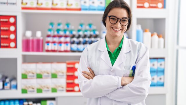 young-hispanic-woman-pharmacist-smiling-confident-standing-with-arms-crossed-gesture-pharmacy